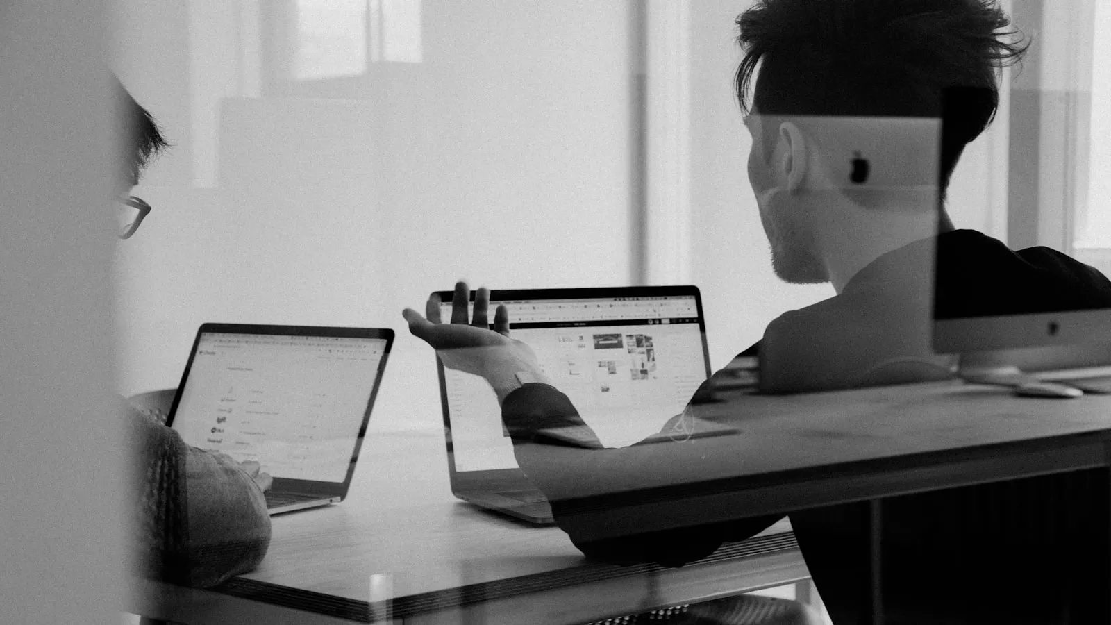 A person working at a laptop, photographed in black and white