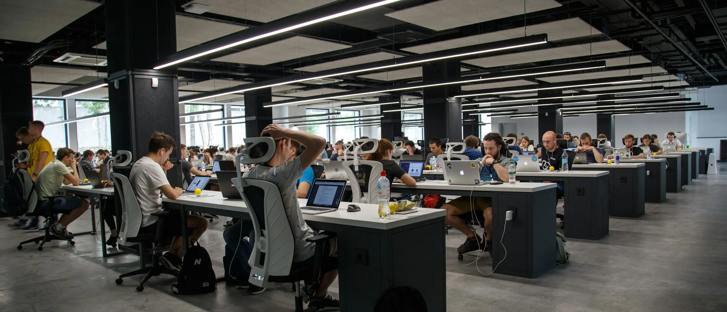 A wide open-plan office floor with rows of desks