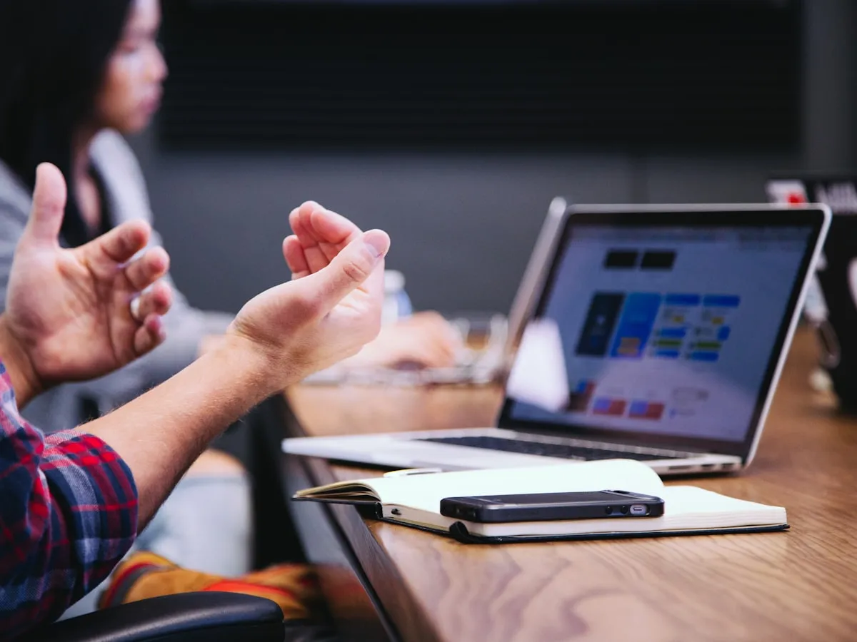 Close-up of hands working at a laptop during a meeting